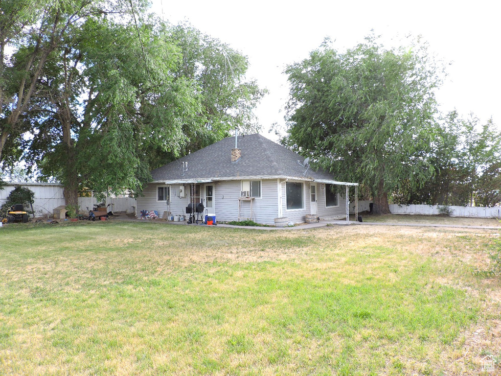 Back of house with a yard