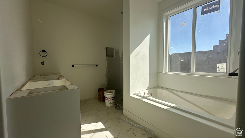 Bathroom with a tub to relax in and tile patterned floors