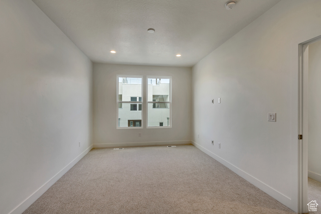 Empty room featuring light colored carpet