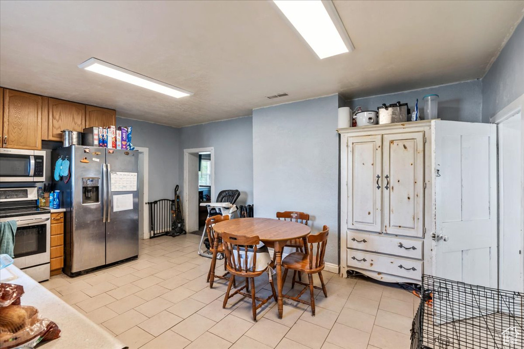 Kitchen featuring appliances with stainless steel finishes and light tile flooring