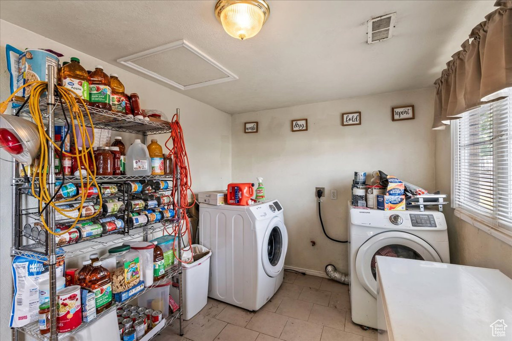 Laundry area featuring hookup for an electric dryer, light tile flooring, and washing machine and clothes dryer