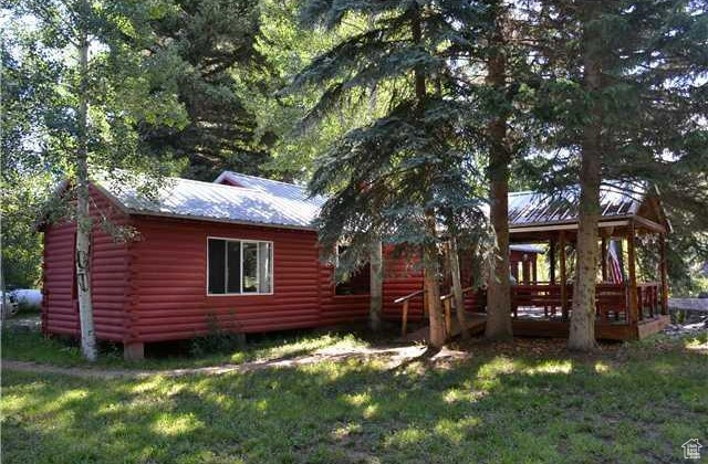 Rear view of property featuring a yard and a wooden deck