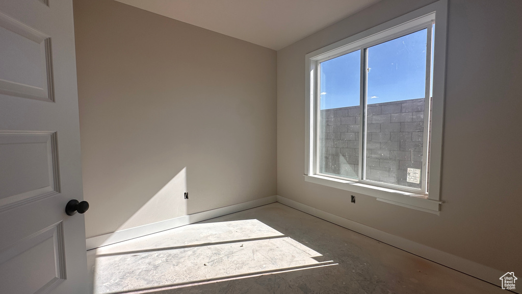 Empty room featuring concrete flooring and a wealth of natural light