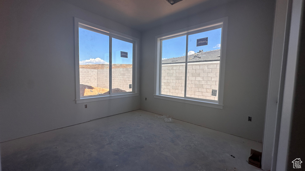 Spare room featuring concrete floors and a healthy amount of sunlight