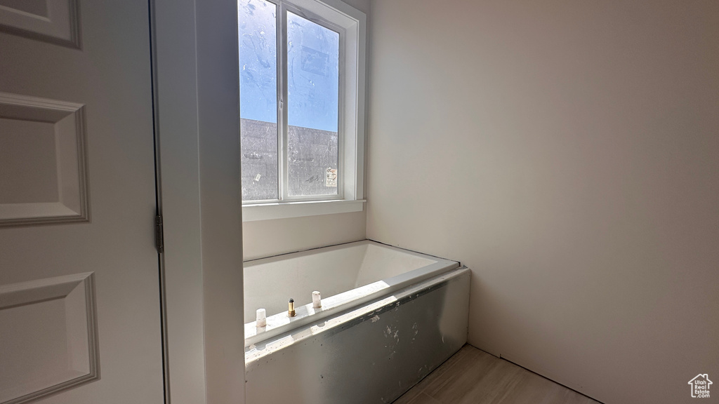 Bathroom with a tub and wood-type flooring