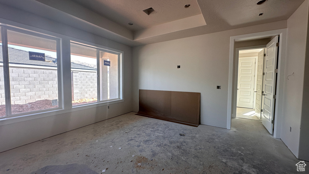 Unfurnished room with a textured ceiling and a tray ceiling