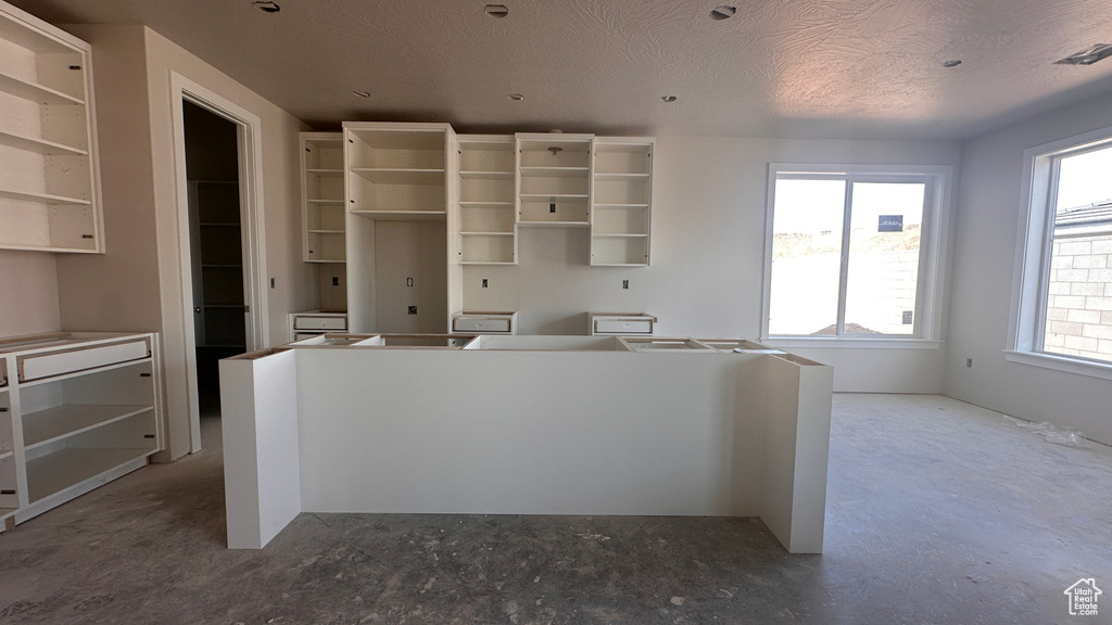 Kitchen featuring a textured ceiling and a wealth of natural light