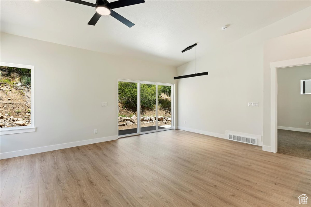 Spare room featuring ceiling fan, light hardwood / wood-style floors, and lofted ceiling