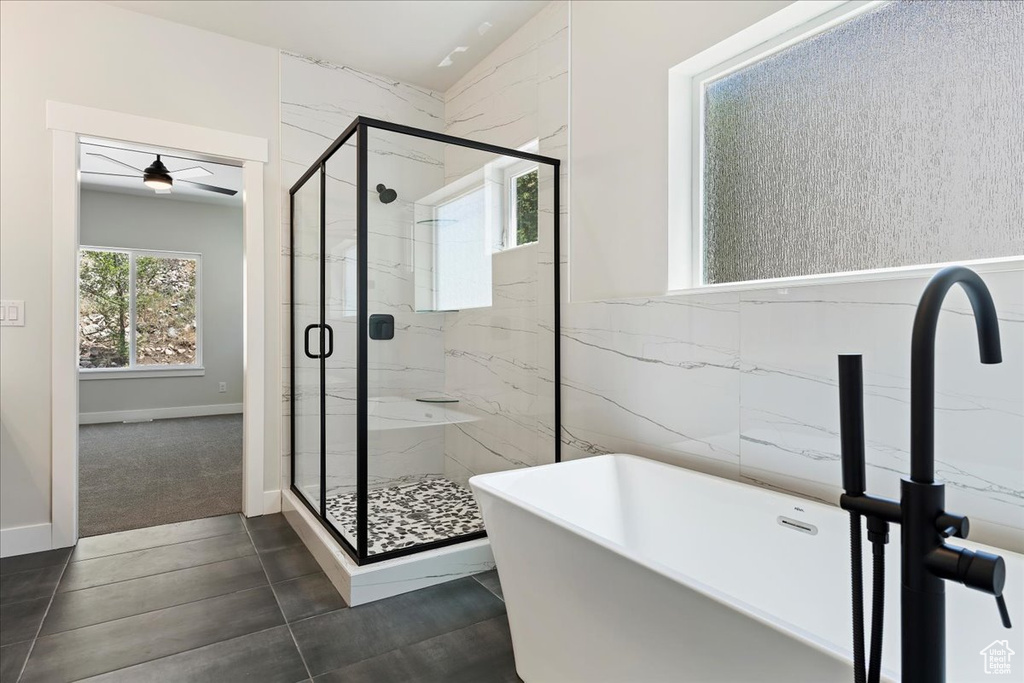 Bathroom featuring a shower with shower door, vaulted ceiling, ceiling fan, and tile floors