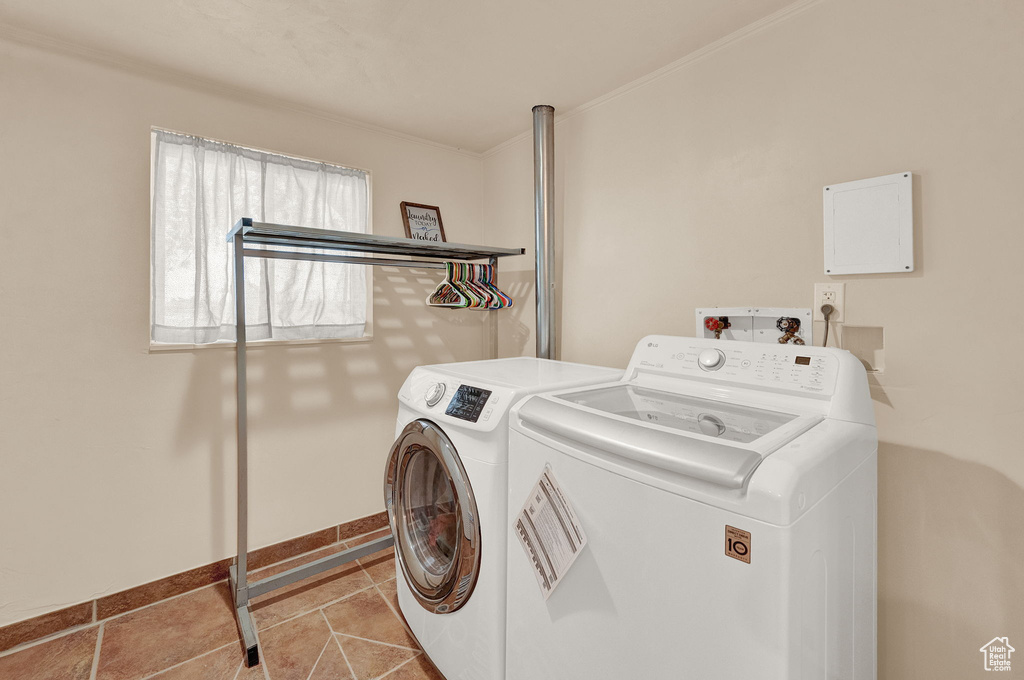 Clothes washing area featuring hookup for a washing machine, crown molding, independent washer and dryer, and light tile floors