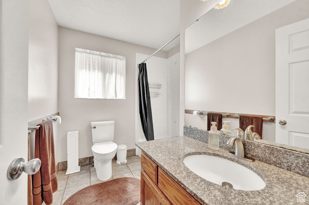 Bathroom featuring tile flooring, toilet, and vanity