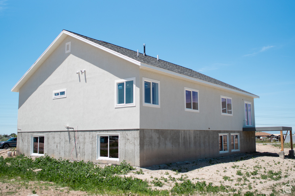View of property exterior featuring stucco siding and roof with shingles