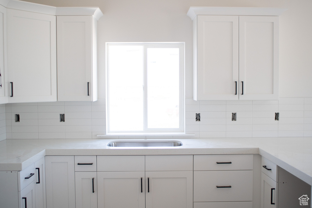 Kitchen with white cabinetry and backsplash