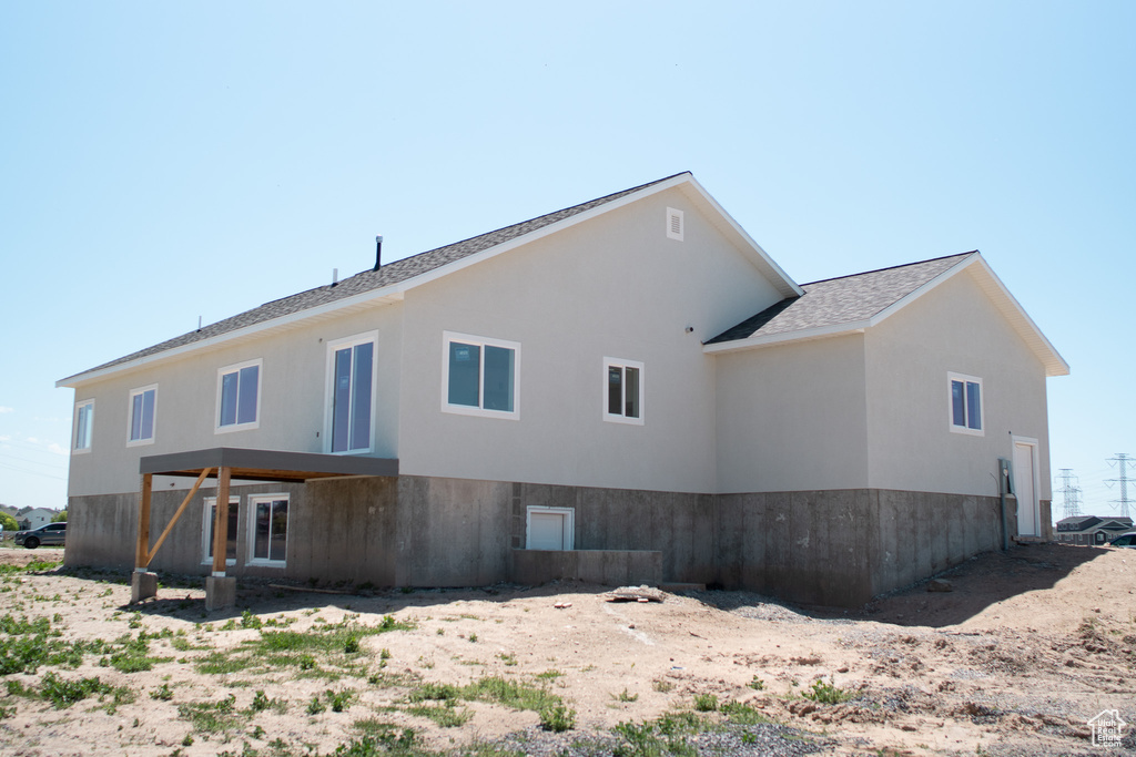 Back of house with a shingled roof