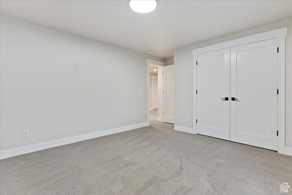 Unfurnished bedroom with carpet and a closet