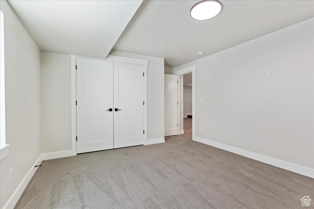 Unfurnished bedroom with carpet and a closet