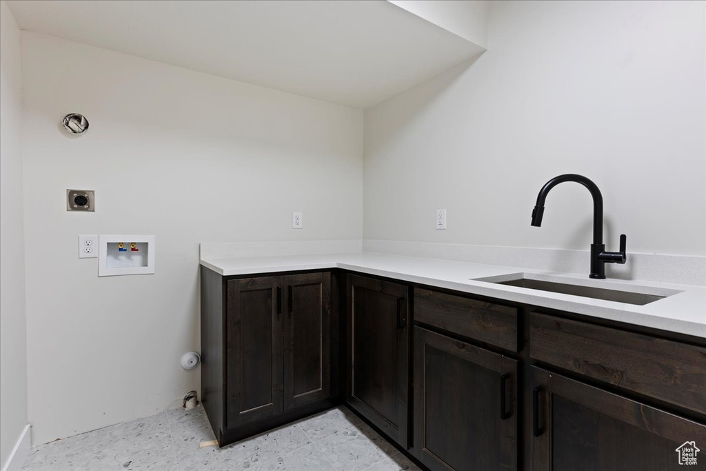 Interior space with sink, dark brown cabinets, and light tile floors