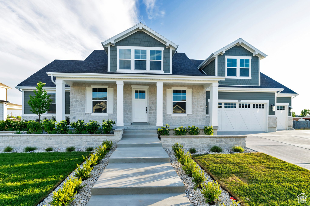 Craftsman house featuring a garage and a front lawn