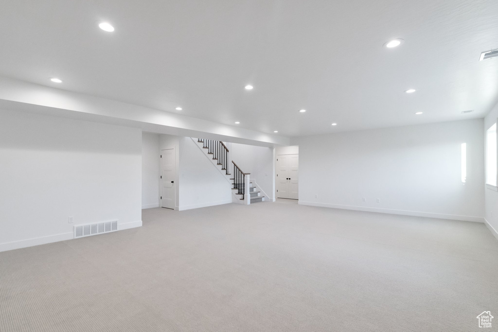 Basement featuring light colored carpet