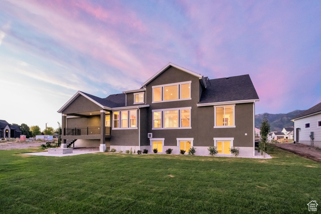 Back house at dusk with a lawn