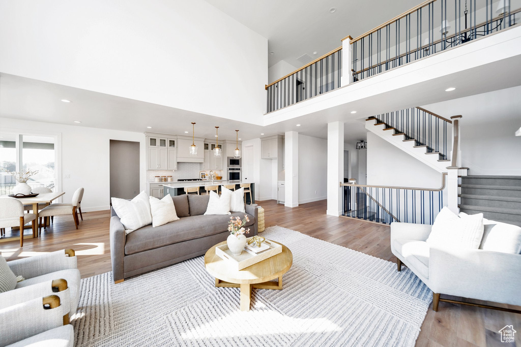 Living room featuring light hardwood / wood-style floors and a high ceiling