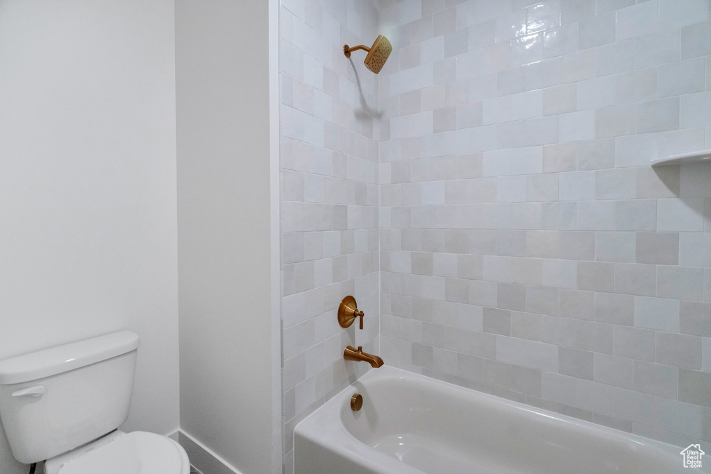 Bathroom featuring toilet and tiled shower / bath combo