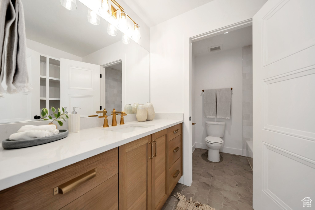 Bathroom featuring tile patterned flooring, toilet, and vanity