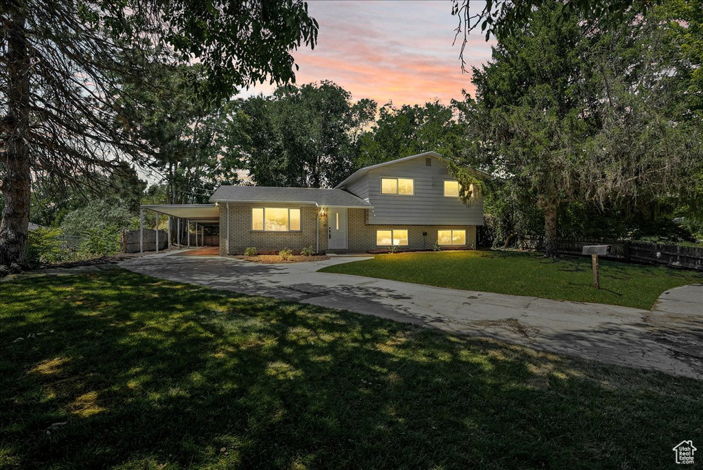 Split level home with a yard and a carport