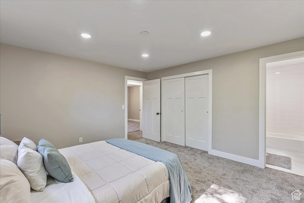 Carpeted bedroom featuring a closet and connected bathroom