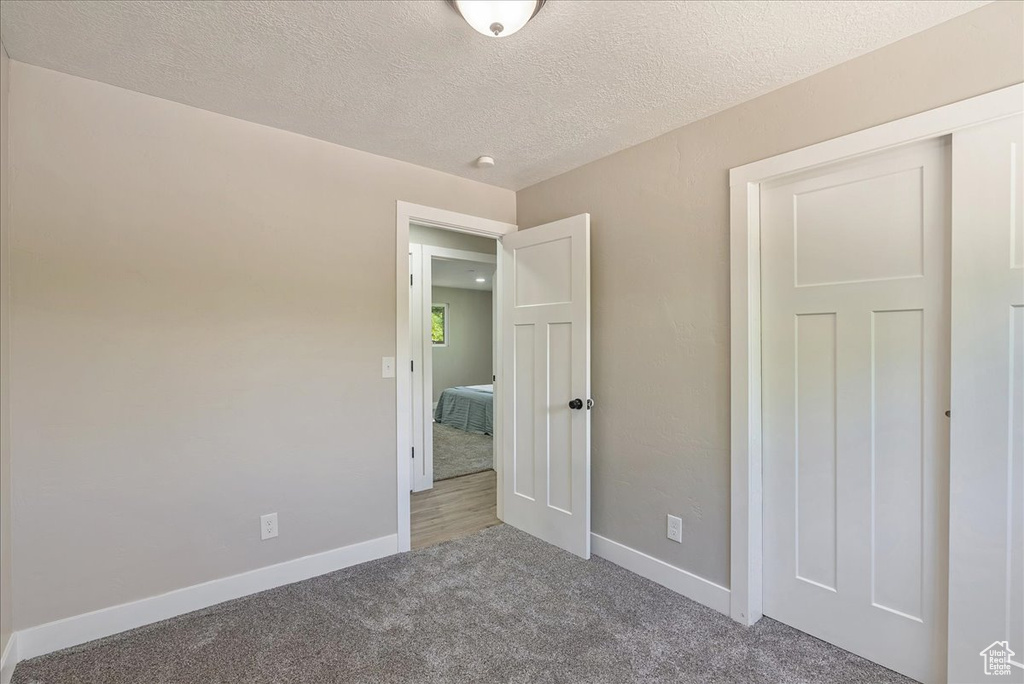 Unfurnished bedroom with hardwood / wood-style floors and a textured ceiling