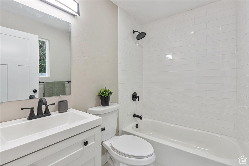 Full bathroom featuring vanity, toilet, and tiled shower / bath combo