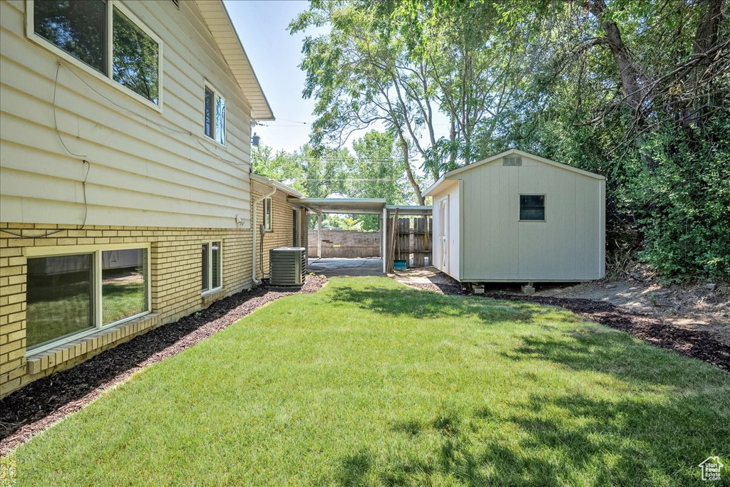 View of yard with a storage shed and central air condition unit