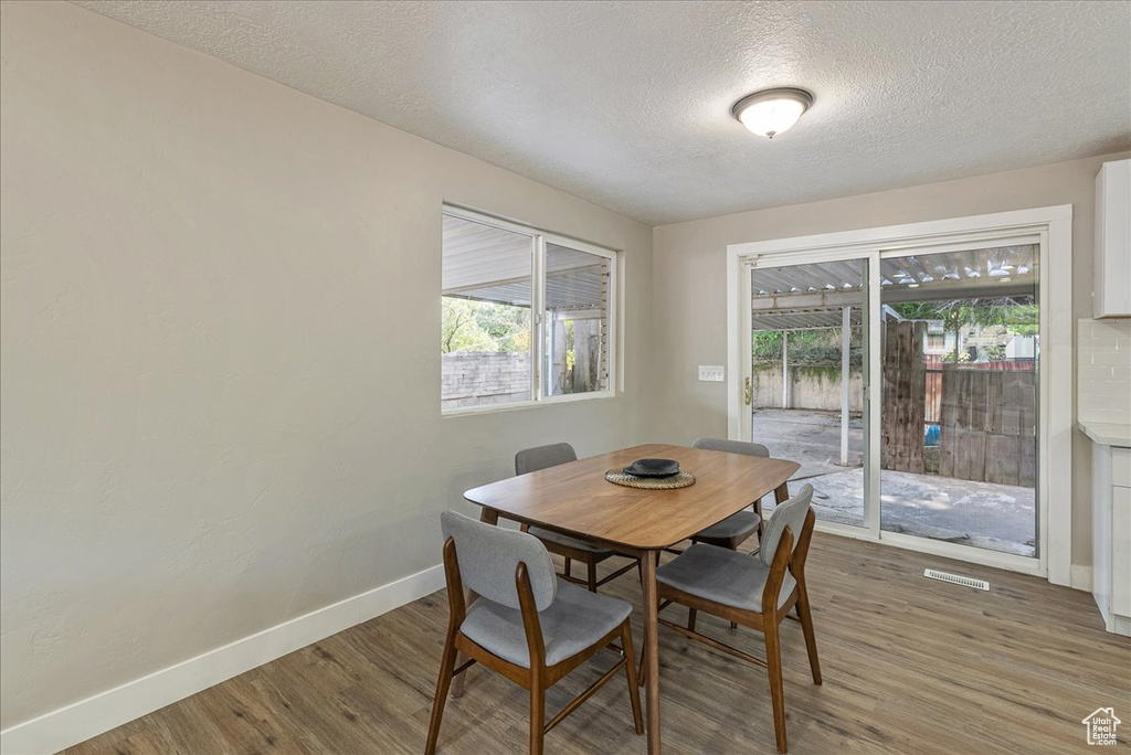 Dining room featuring a textured ceiling and wood-type flooring