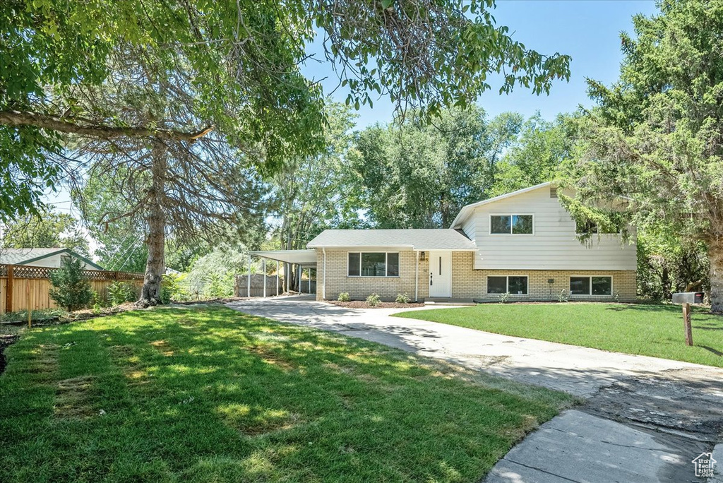 Rear view of property featuring a yard and a carport