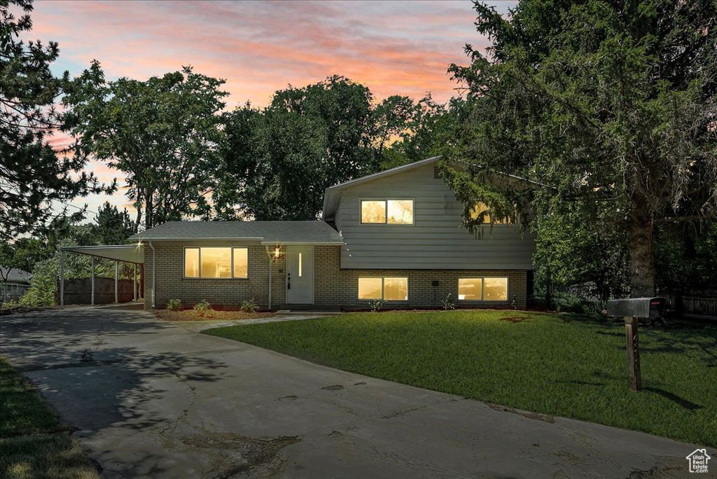 Split level home featuring a carport and a lawn