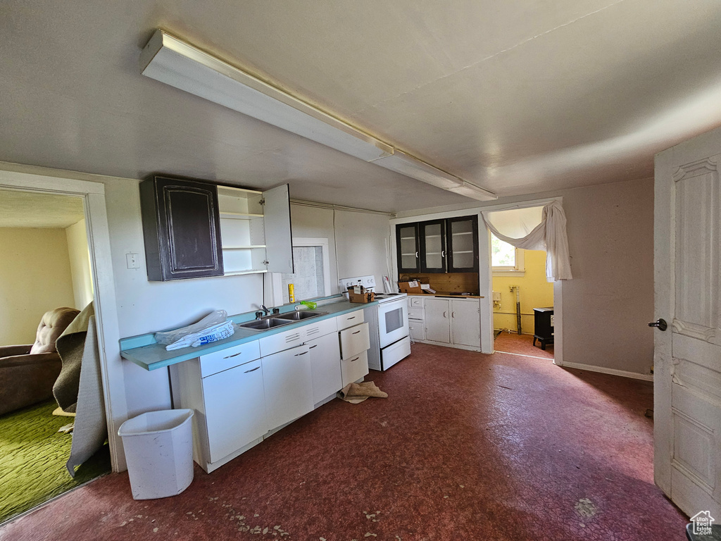 Kitchen featuring white cabinets, sink, and white electric stove