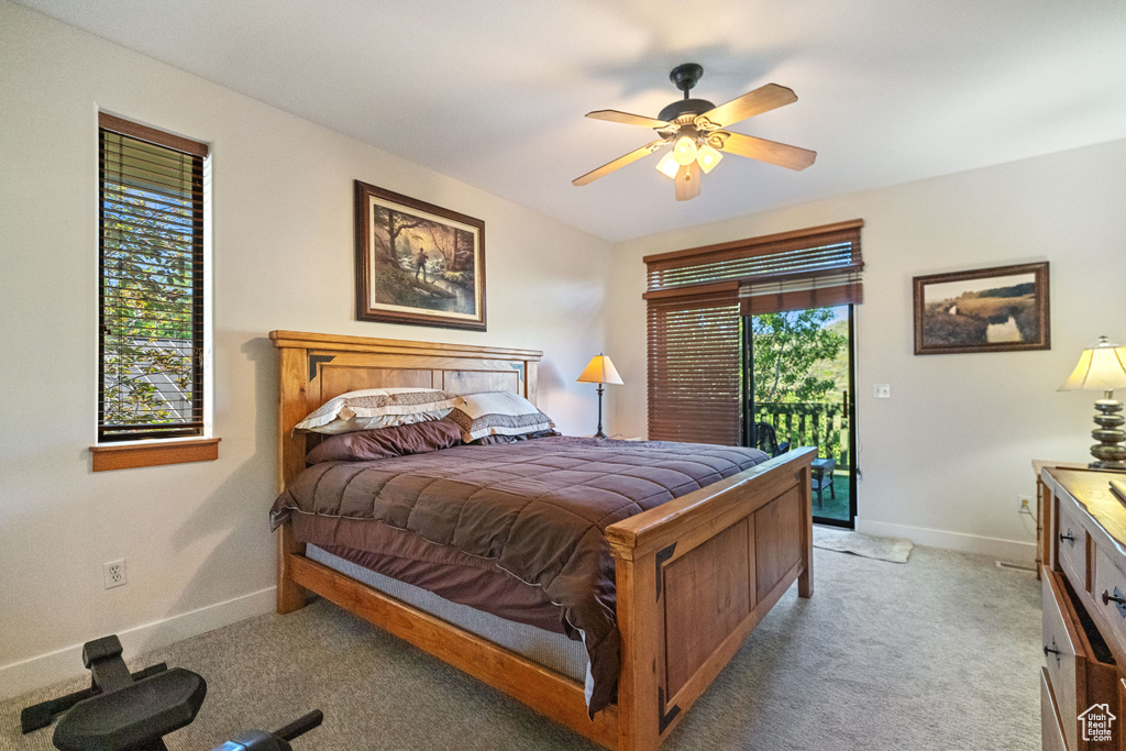 Bedroom with ceiling fan, multiple windows, and light carpet