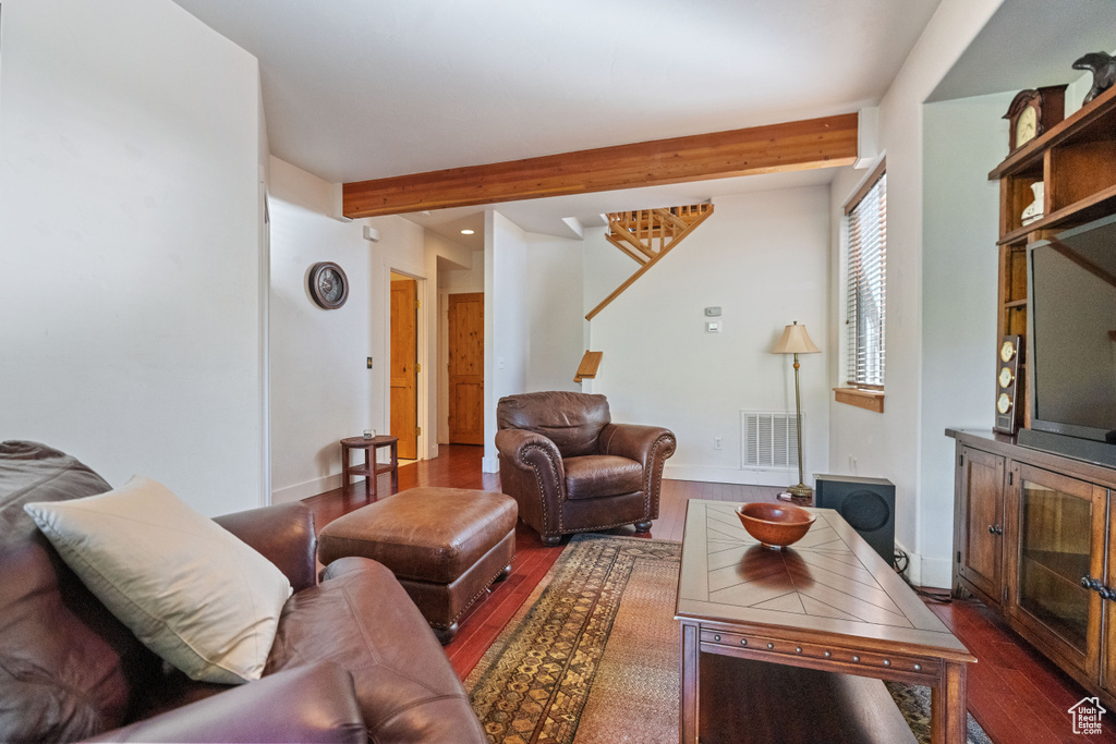 Living room with beamed ceiling and dark hardwood / wood-style flooring