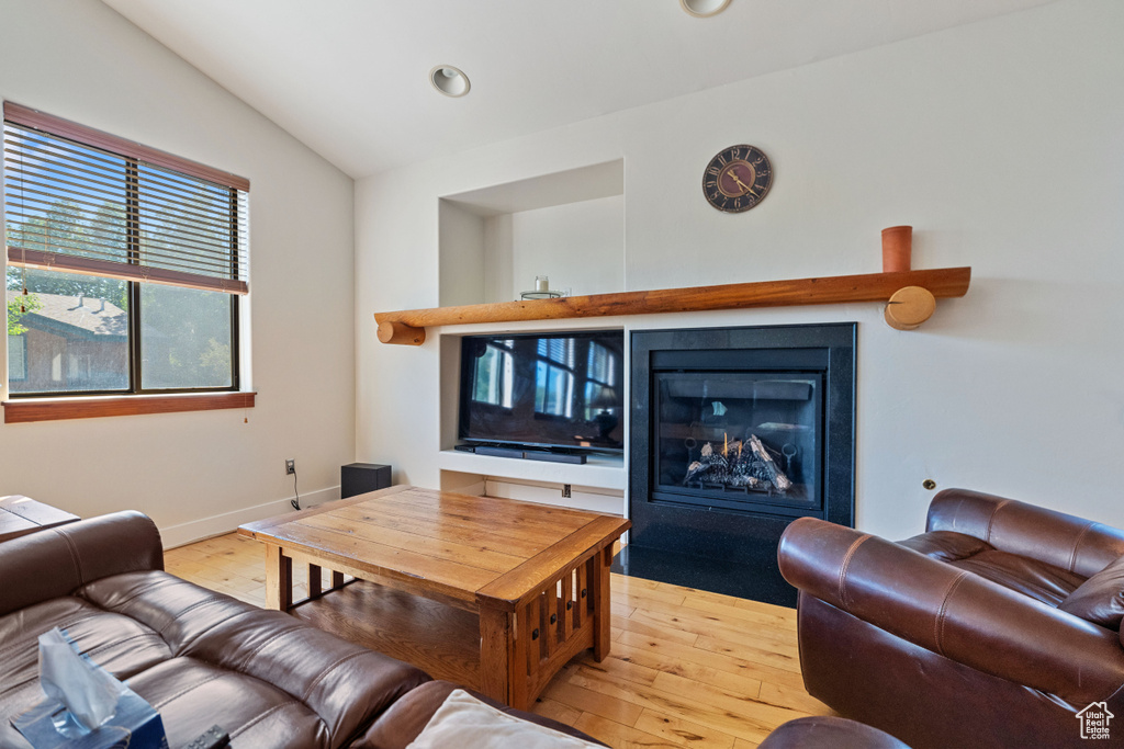 Living room with light hardwood / wood-style flooring and lofted ceiling