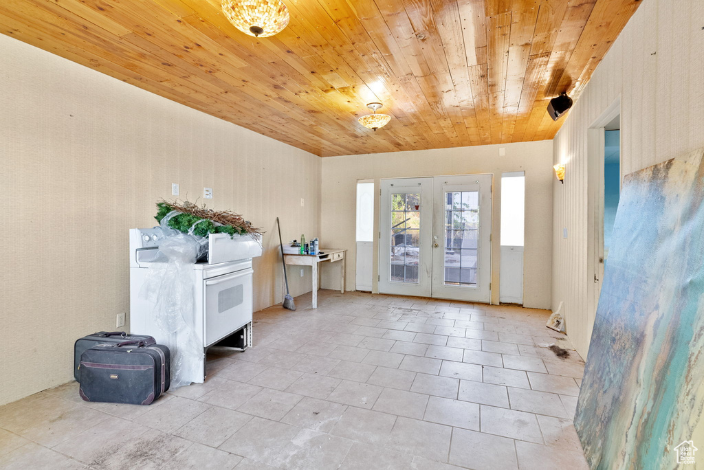 Interior space featuring french doors, wood ceiling, and light tile floors