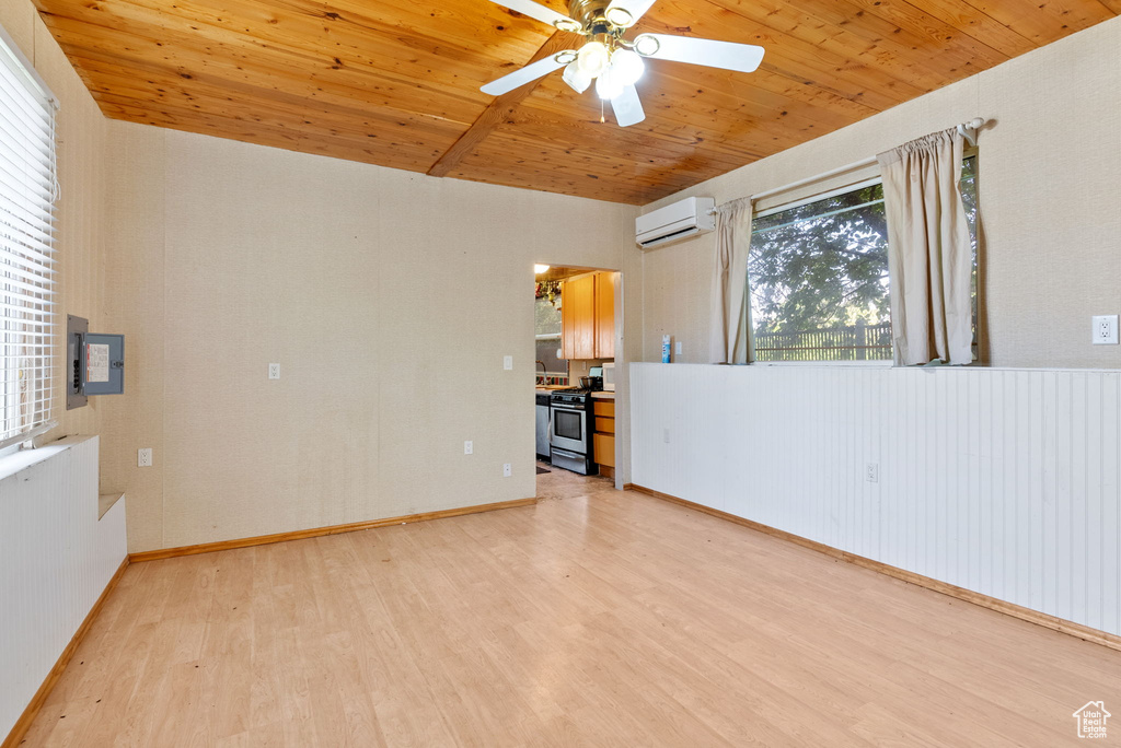 Unfurnished room with an AC wall unit, ceiling fan, light hardwood / wood-style floors, and wood ceiling