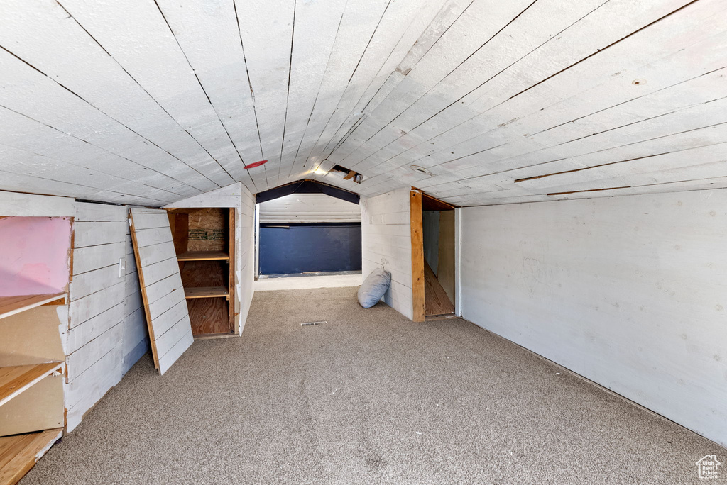 Bonus room featuring lofted ceiling and carpet