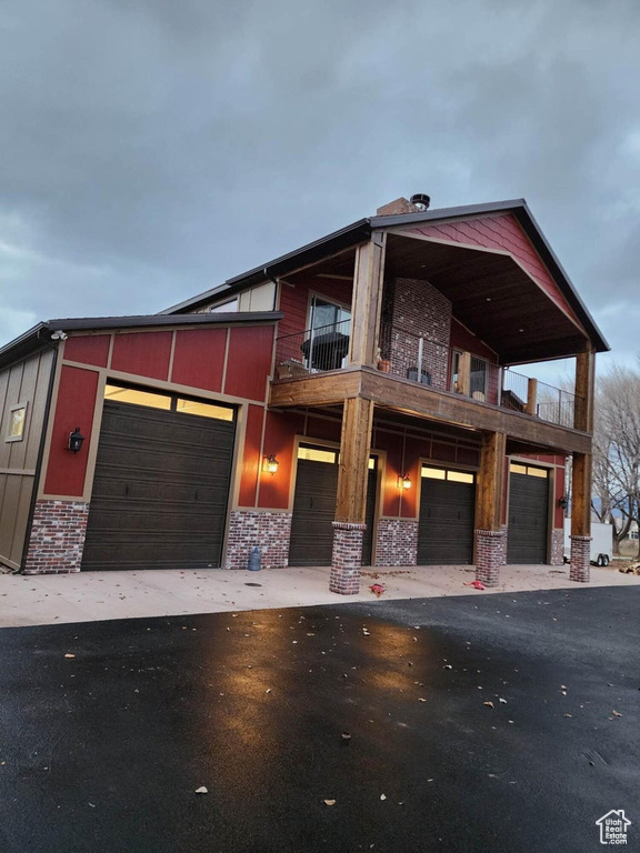 View of front of home with a garage and a balcony