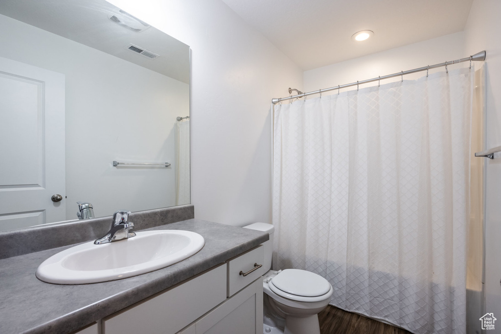 Bathroom featuring toilet, oversized vanity, and hardwood / wood-style floors