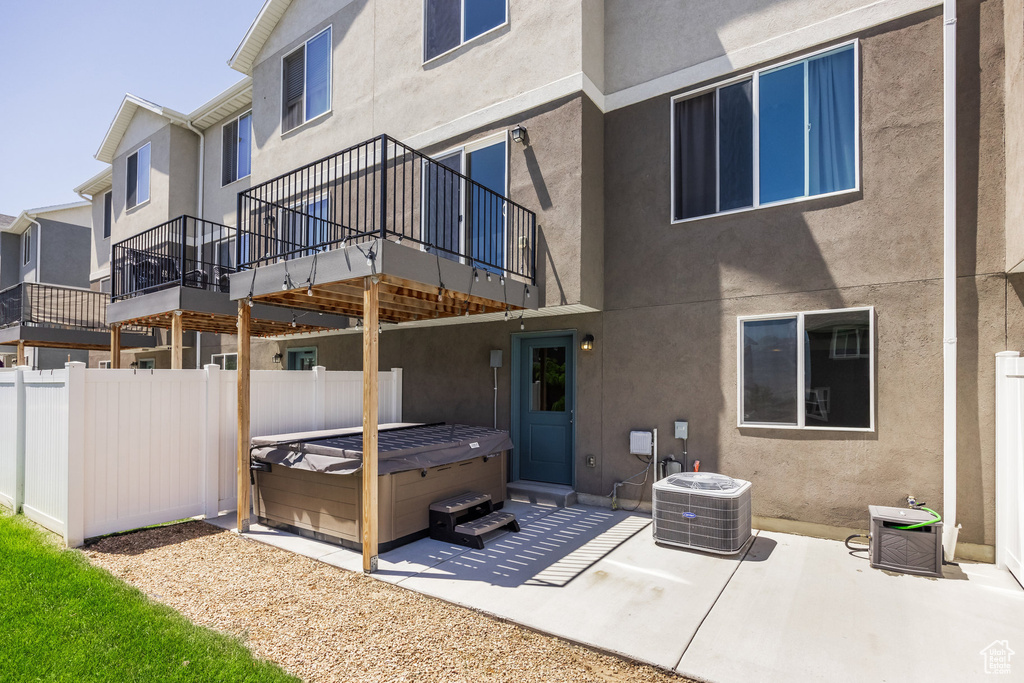 Back of house with a patio area and a hot tub