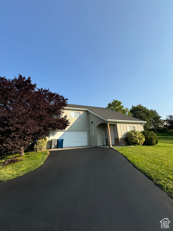 View of front of house with a garage and a front lawn