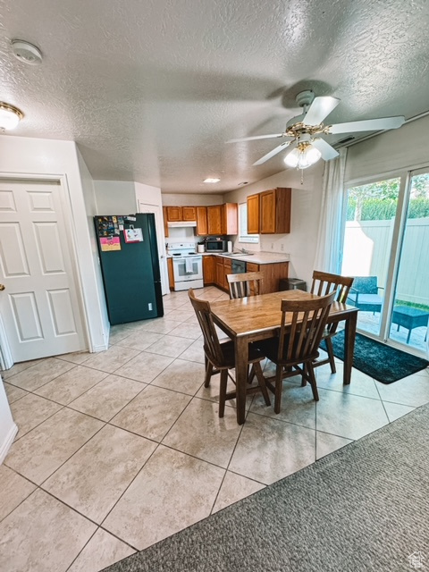 Tiled dining area featuring sink, a textured ceiling, and ceiling fan