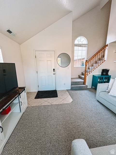 Carpeted entryway with vaulted ceiling