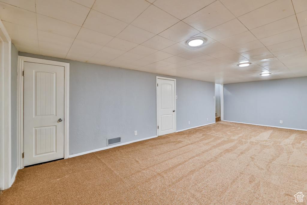 Basement featuring a drop ceiling and carpet floors