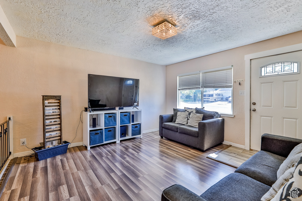 Living room featuring a textured ceiling and hardwood / wood-style floors